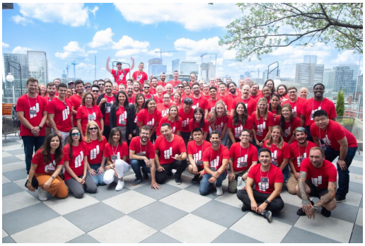 Large group photo of the Paradigm team in red shirts on a rooftop